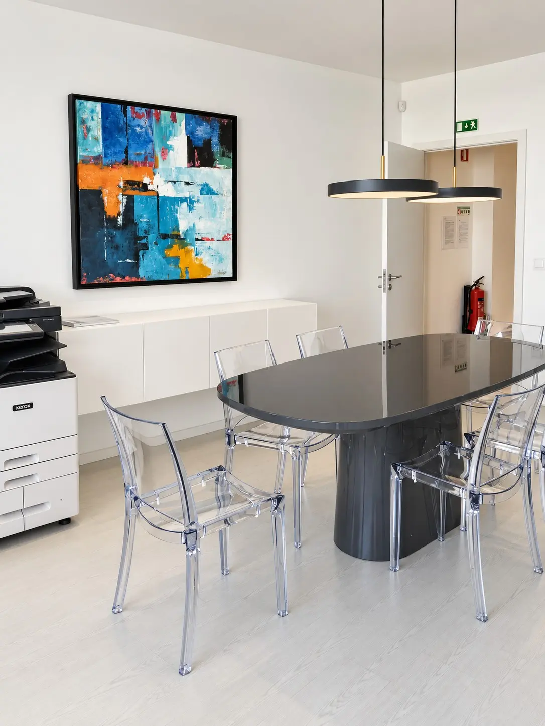 Sala de reuniões da Pormenor, com mesa oval e quadro abstrato na parede